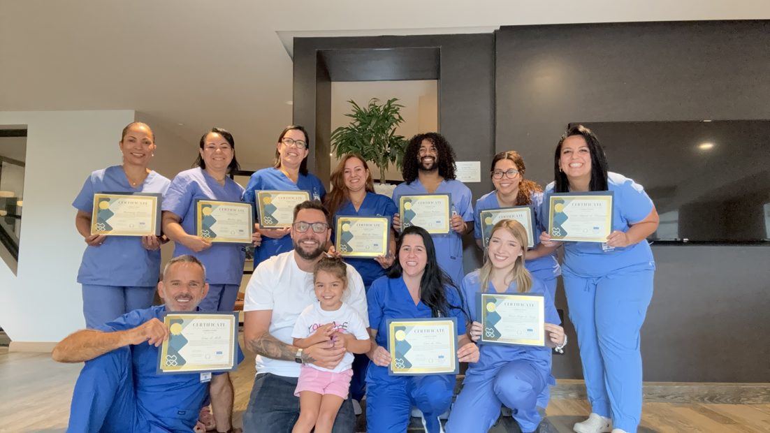 Turma da School LAR reunida exibindo os certificados de Home Health Aide