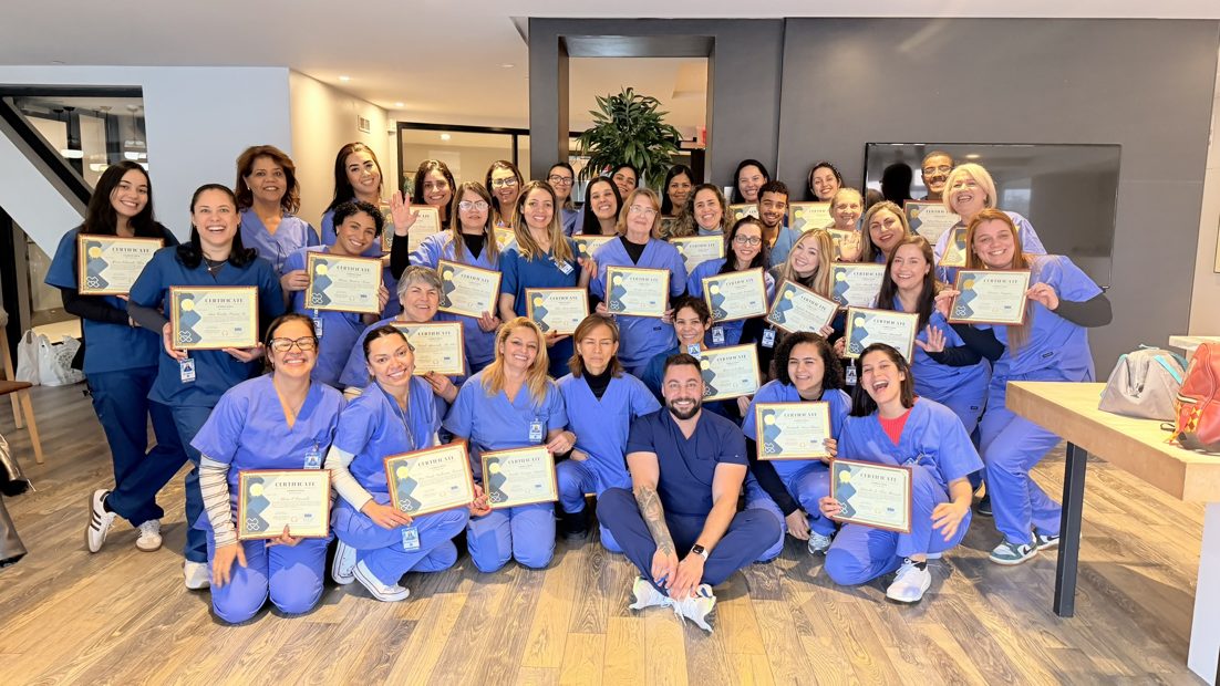 Turma numerosa segurando os certificados de conclusao do curso