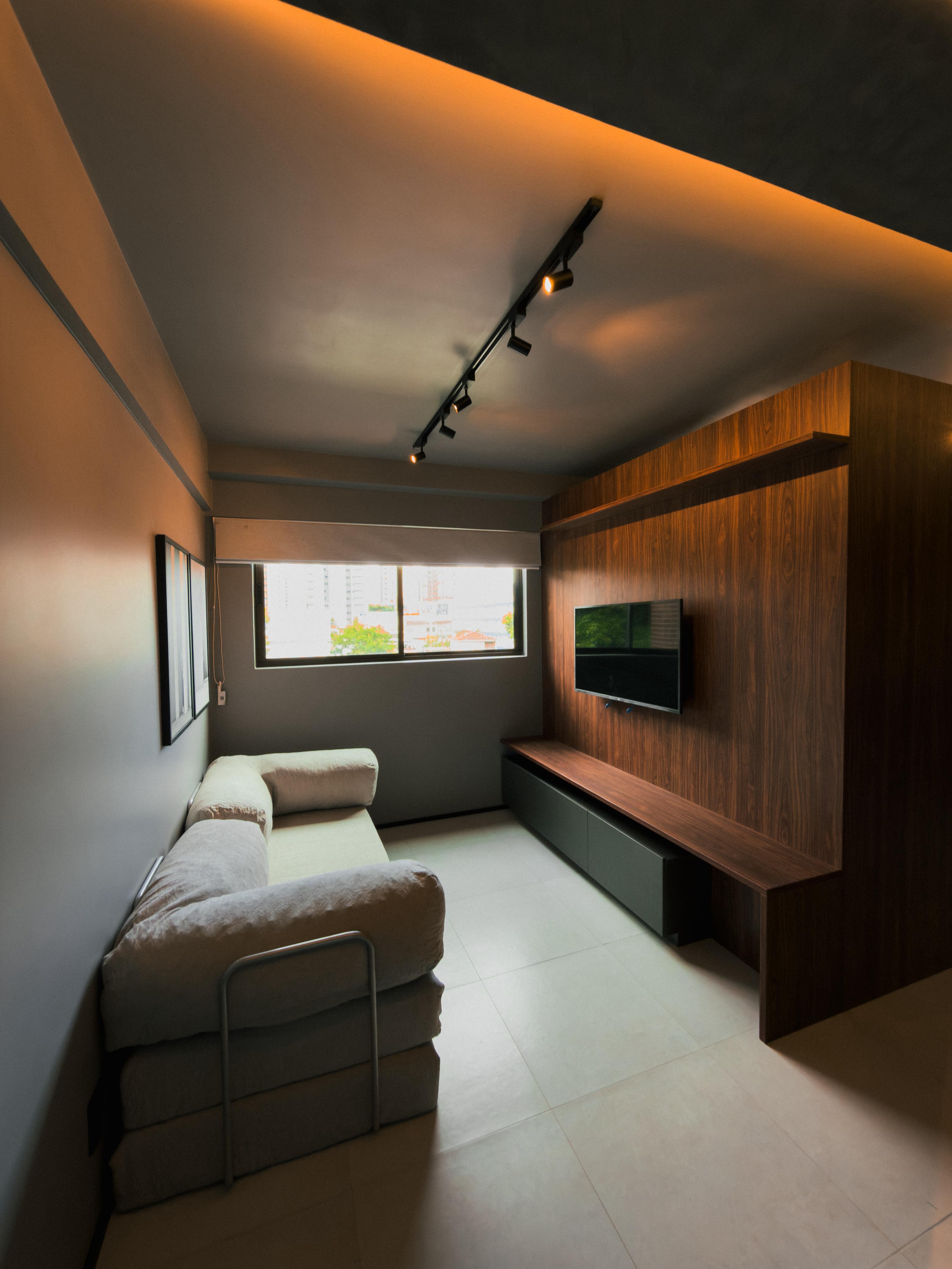 Studio 305 — sala estar com painel de madeira e iluminação indireta